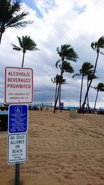 Information sign on beach against sky
