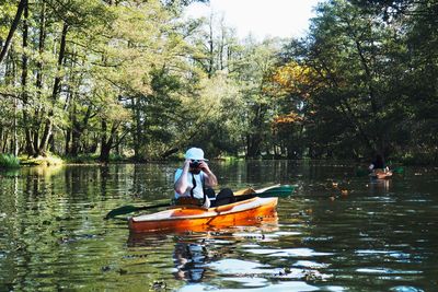 Mid adult man sitting in boat on lake