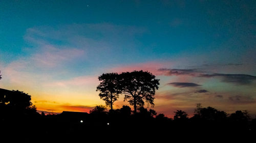 Low angle view of silhouette trees against romantic sky