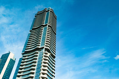 Low angle view of modern building against blue sky