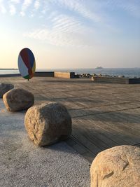 Rocks on beach against sky during sunset