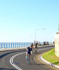 People walking on bridge over sea