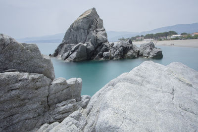 Rock formations by sea against sky