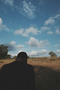 Rear view of man on field against sky