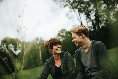 Young man and woman against plants