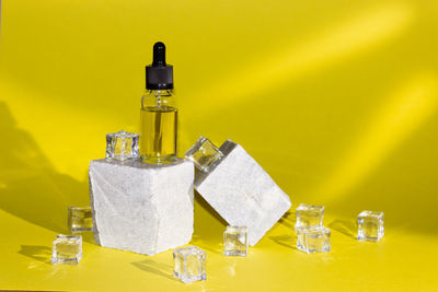 Close-up of bottles on table against wall