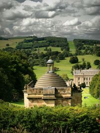 Built structure on landscape against cloudy sky