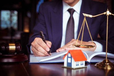 Midsection of man holding camera on table