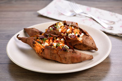 Baked sweet potato stuffed with chopped sun-dried tomatoes, olives, feta cheese and basil  