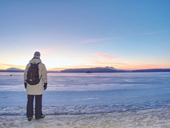 Rear view of man standing on snow covered land