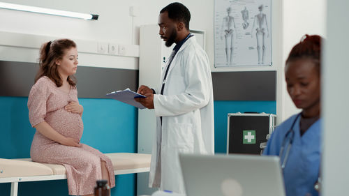 Female doctor examining patient in office