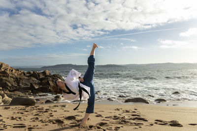 Girl doing martial arts karate, taekwondo, on the beach