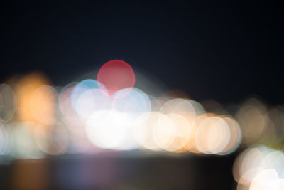 Defocused image of lights against sky at night