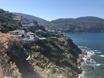 Scenic view of sea by buildings against clear sky