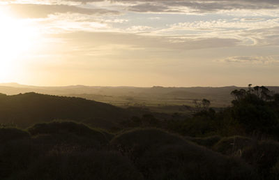 Scenic view of field against sky at sunset