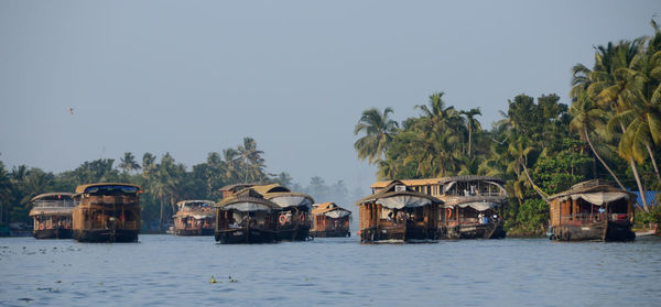 Built structures by palm trees against clear sky