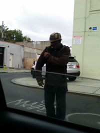 Man on street against sky in city