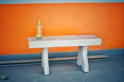 White stone chair with orange wall background