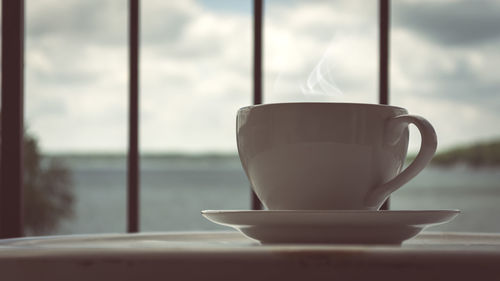 Close-up of coffee cup against sky