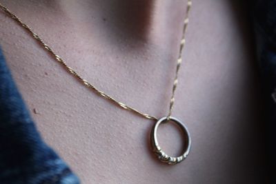 Close-up of woman wearing ring in chain