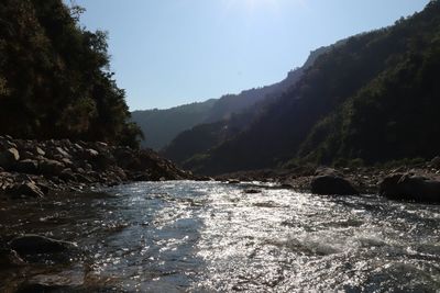 Scenic view of river and mountains against clear sky