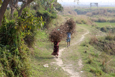 Rear view of woman walking on field