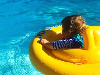 Baby boy on inflatable ring in swimming pool