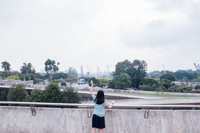 Women standing on terrace against cloudy sky