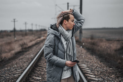 Young woman standing on railroad track