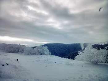 Scenic view of mountain range against cloudy sky