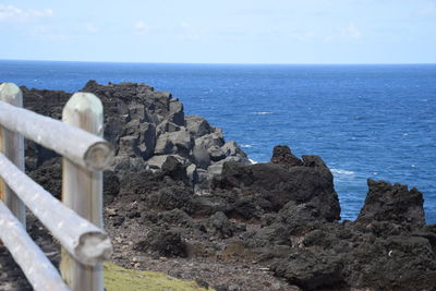 Rocks on sea shore against sky