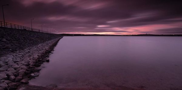 Scenic view of sea against dramatic sky during sunset