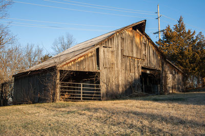 Old barn on field against clear sky