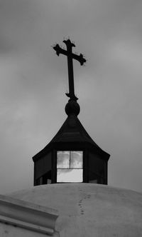 Low angle view of weather vane against sky