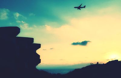 Low angle view of silhouette airplane against sky during sunset