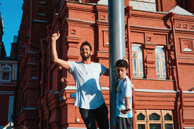 Full length of young woman standing against building