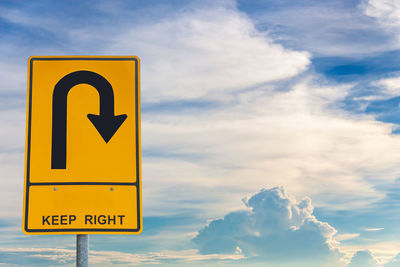 Low angle view of road sign against sky