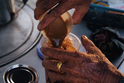 Close-up of hand holding milk tea.