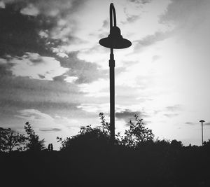Low angle view of silhouette tree against cloudy sky
