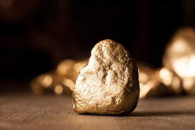 Close-up of golden rock on table