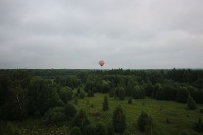 View of hot air balloons on field against sky