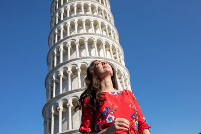 Woman standing against leaning tower of pisa in italy