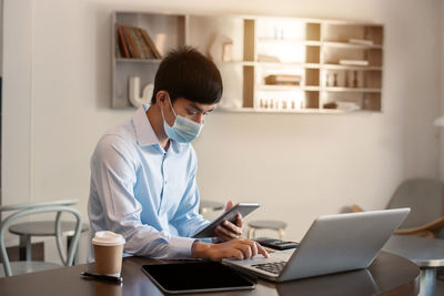 Young woman using laptop at table