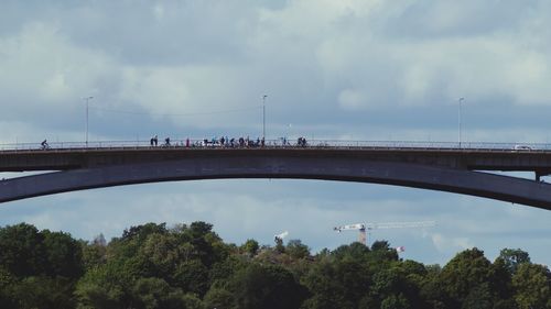 Bridge over river against sky in city