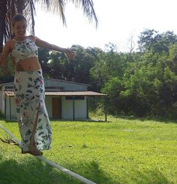 Full length of girl standing on grass against sky