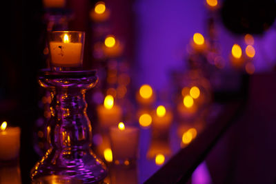 Close-up of illuminated candles on table