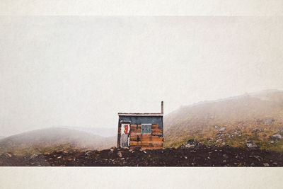 Lifeguard hut on building by mountain against sky