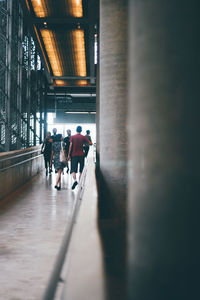 Rear view of people walking in corridor