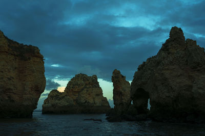 Rock formations by sea against sky