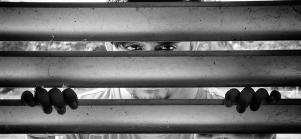 Portrait of young man looking through window